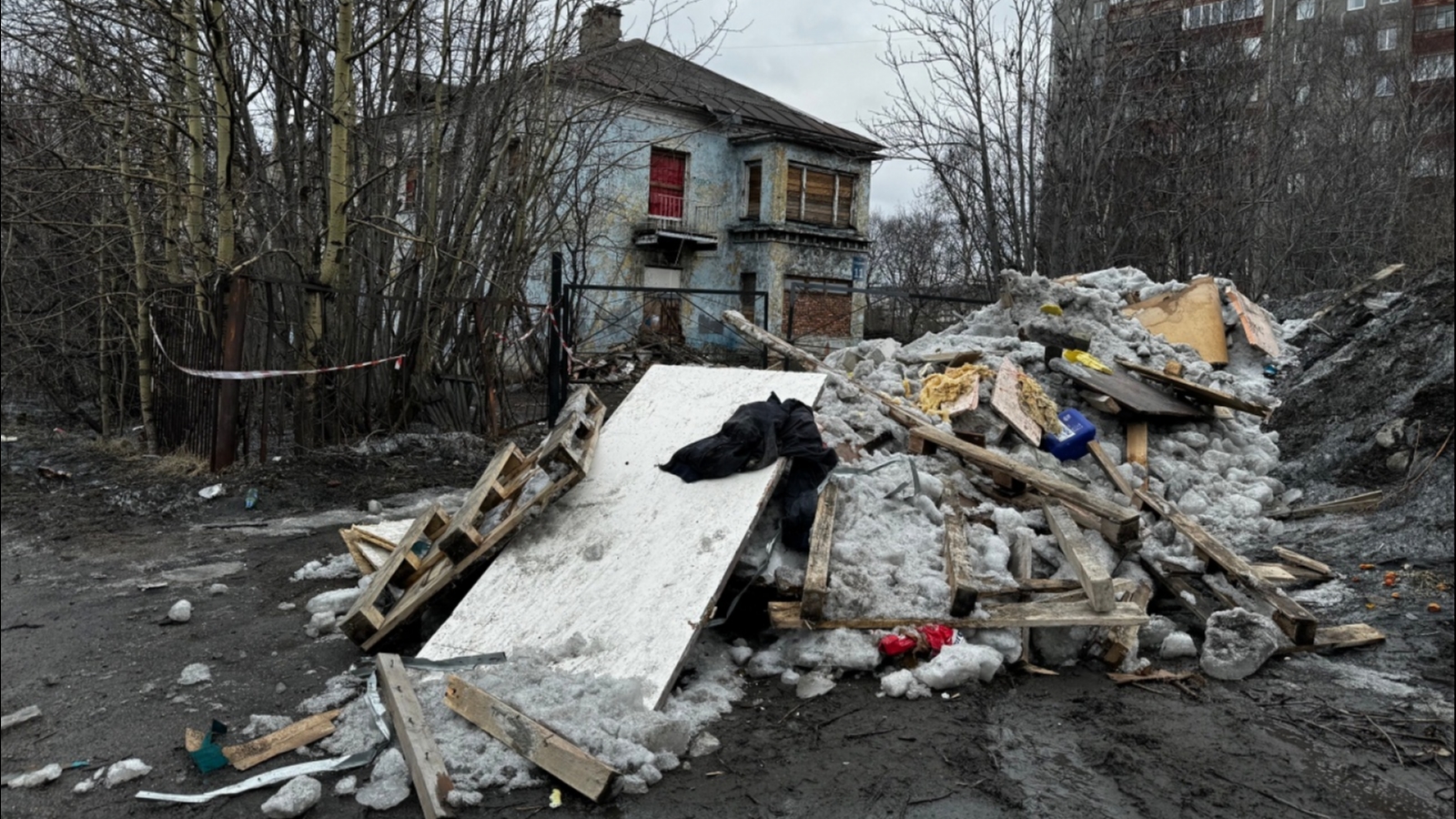 К заброшенному зданию в Мурманске «КАМАЗами» вывозят мусор 