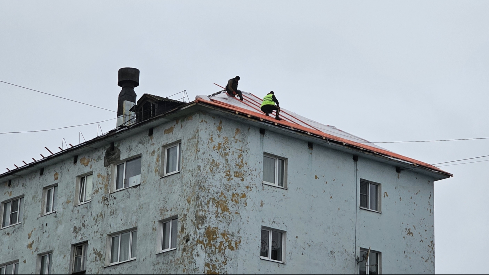 Рабочие в Мурманске ремонтируют крышу без страховки